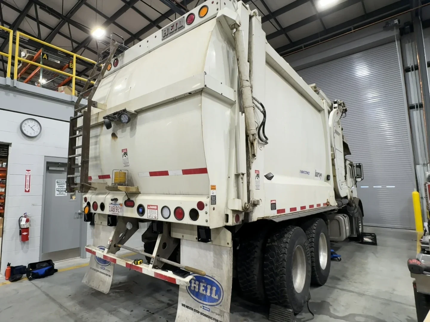 Heil rear-load garbage truck parked in a service bay