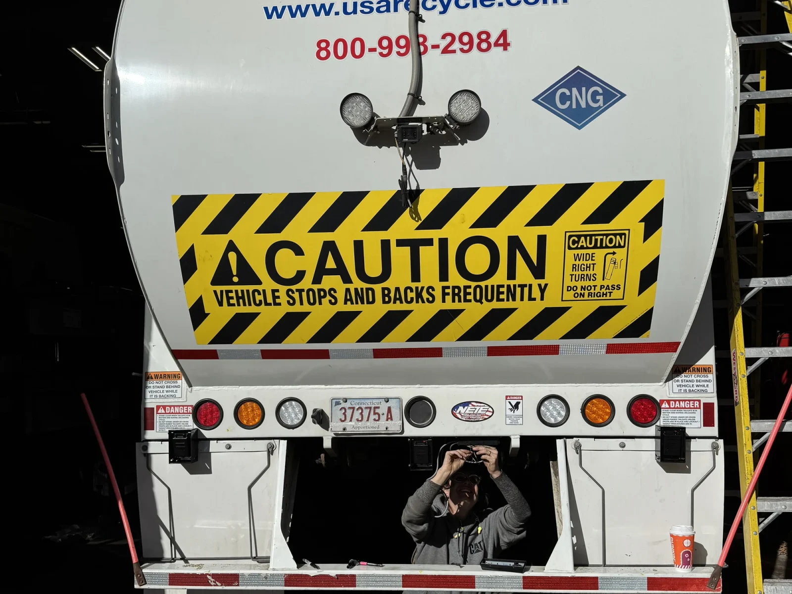 Rear of a CNG recycling truck in a shop during a sensor install