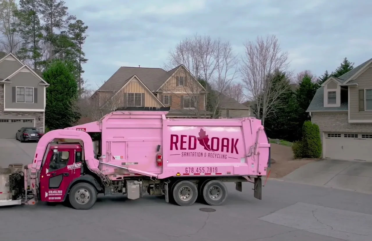 Red Oak Sanitation front-load garbage truck on a residential street