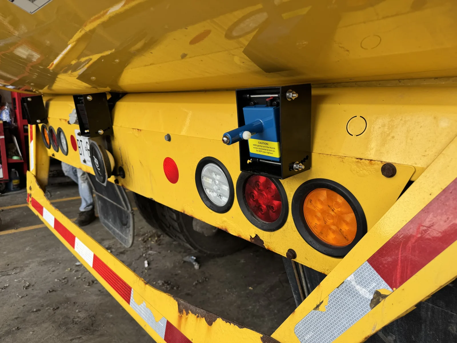 Alignment tool fitted to a rear sensor mounting box on a yellow truck